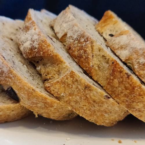 olive and herb artisan bread sliced on a plate