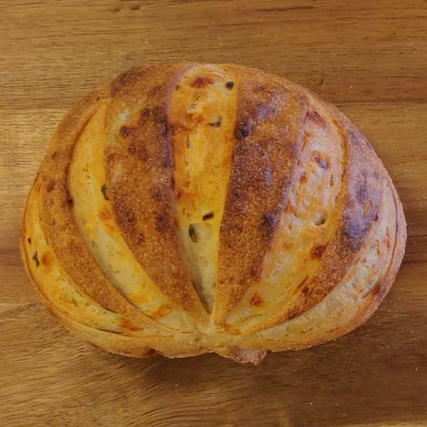 jalapeno and cheese cob sitting on a bread board artisan sourdough